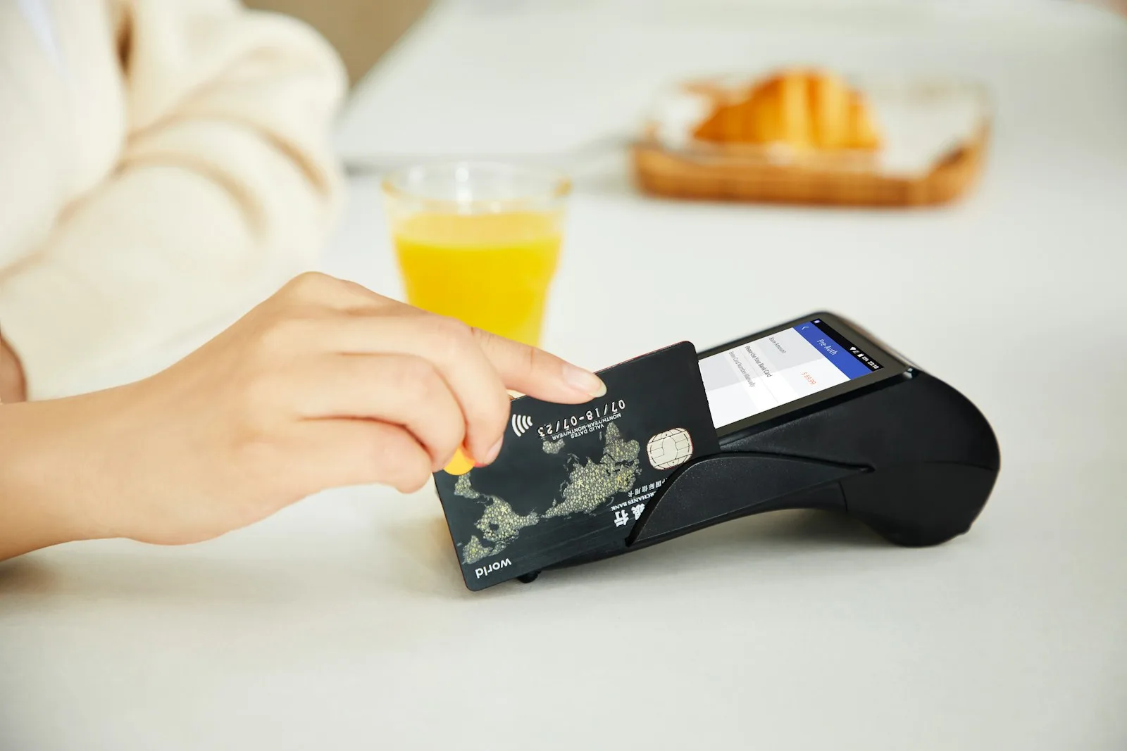 Photo of a person using their credit card at a POS.