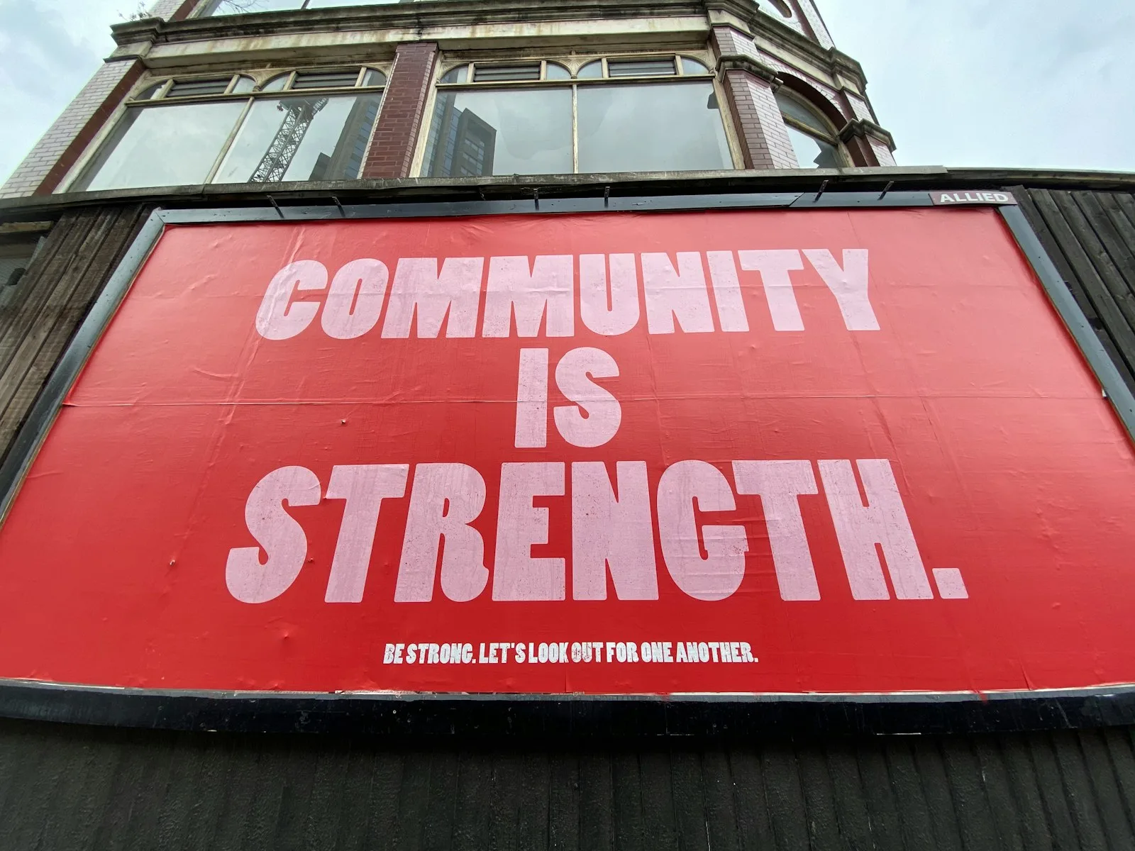 Photo of a street sign stating the words “Community is Strength”