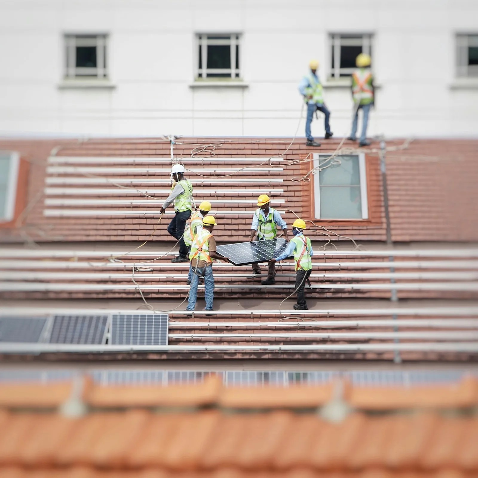 A homeowner installing solar panels on their roof in order to cut down on electricity expense of the house
