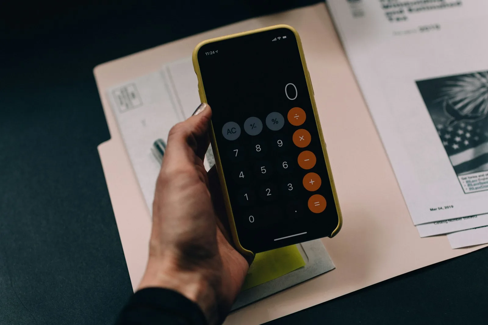 A person creating a budget using a calculator on their mobile phone