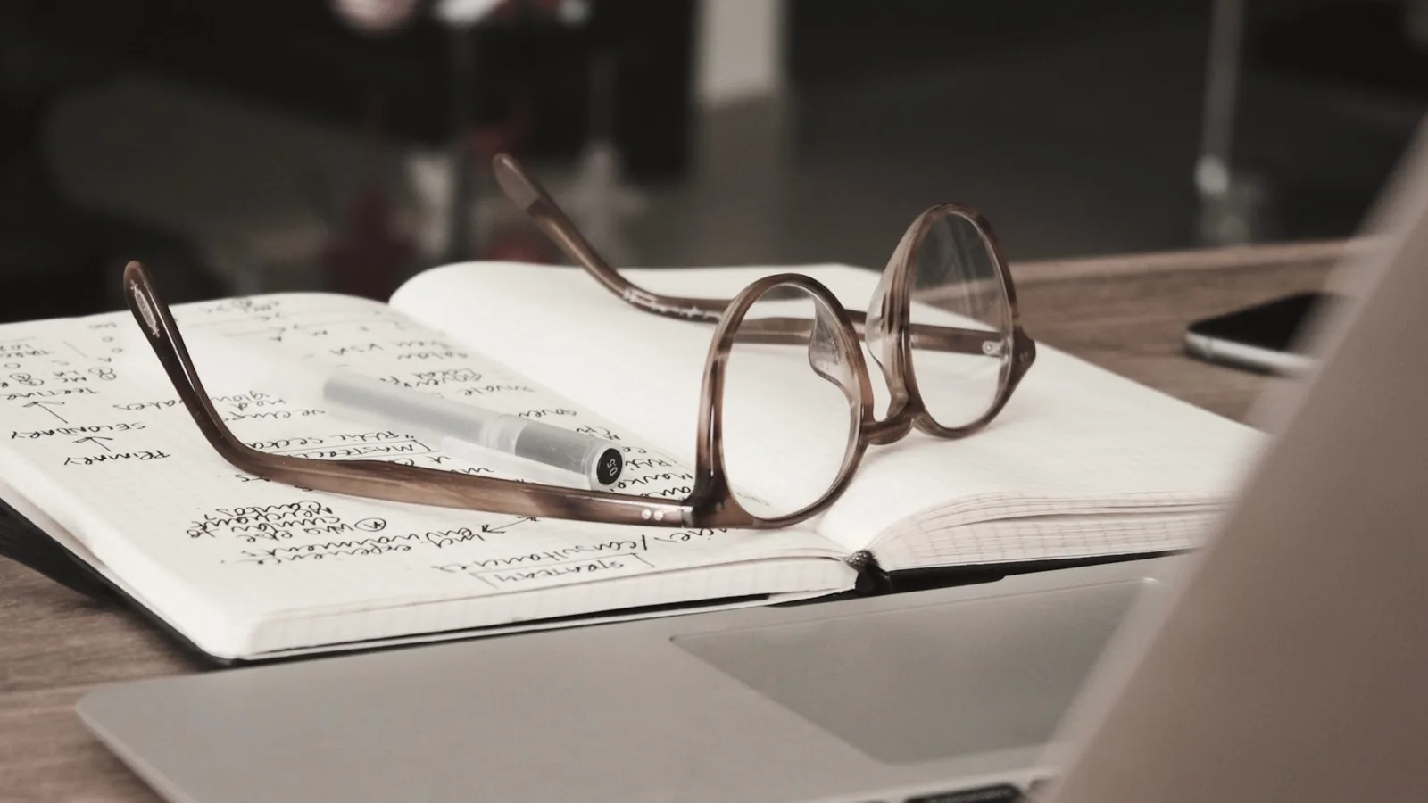 Image of a person doing research over the internet and writing them down in a notepad