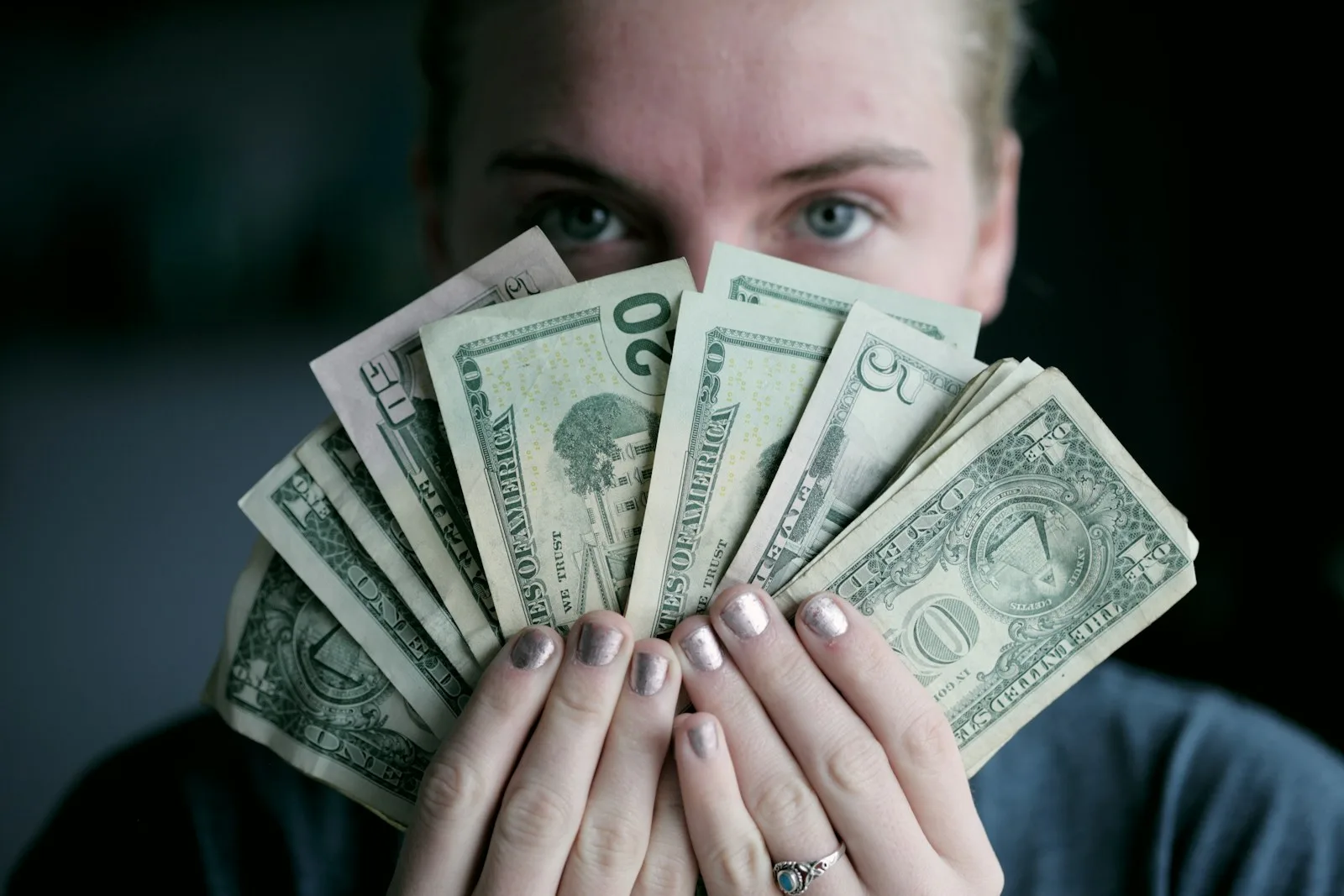 Photo of a lady showing off her dollar bills