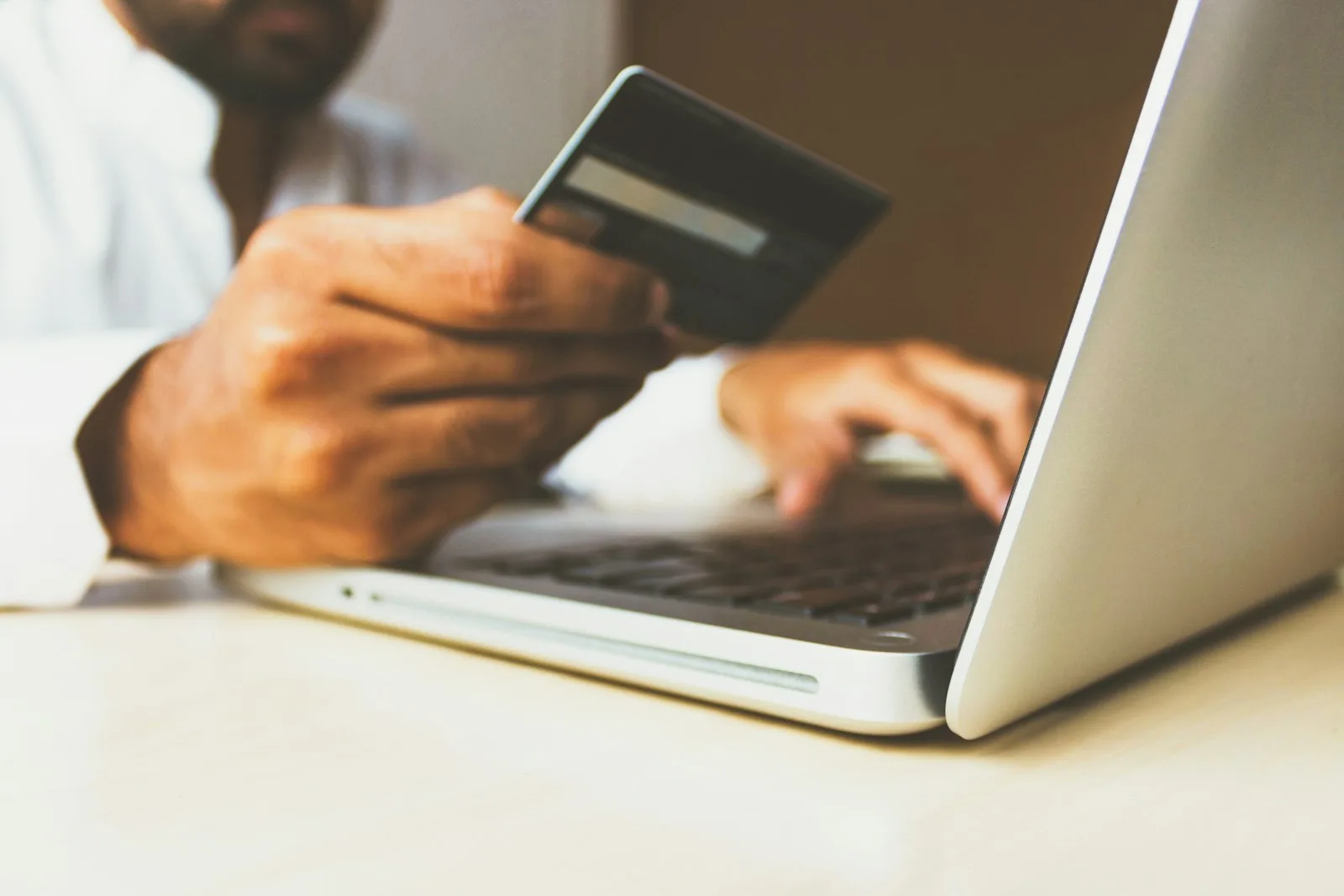 Image of a person making a purchase by using his credit / debit card