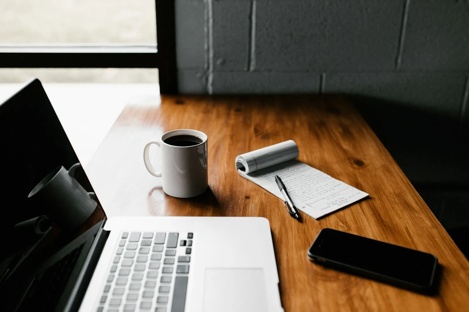 Photo of a laptop with a cup of coffee and notebook, where a person was preparing for their first credit counselling session