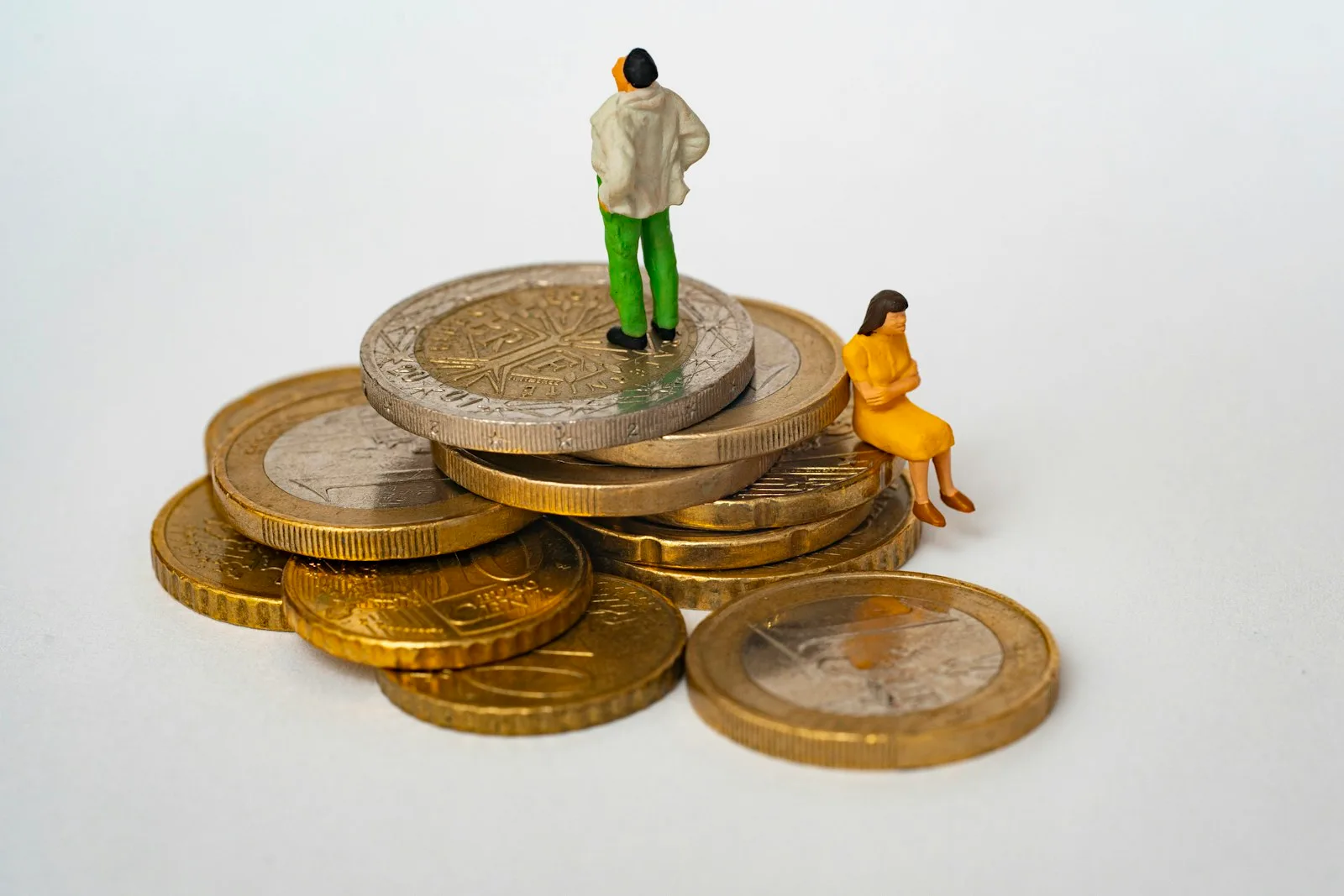 An abstract image of a couple standing over coins and trying to figure out finance
