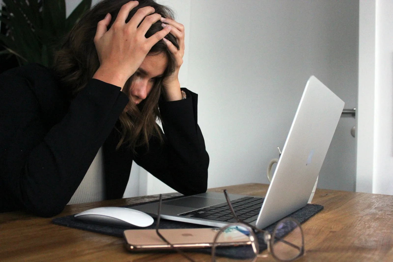 A young lady looking stressed after checking all her financial debts.