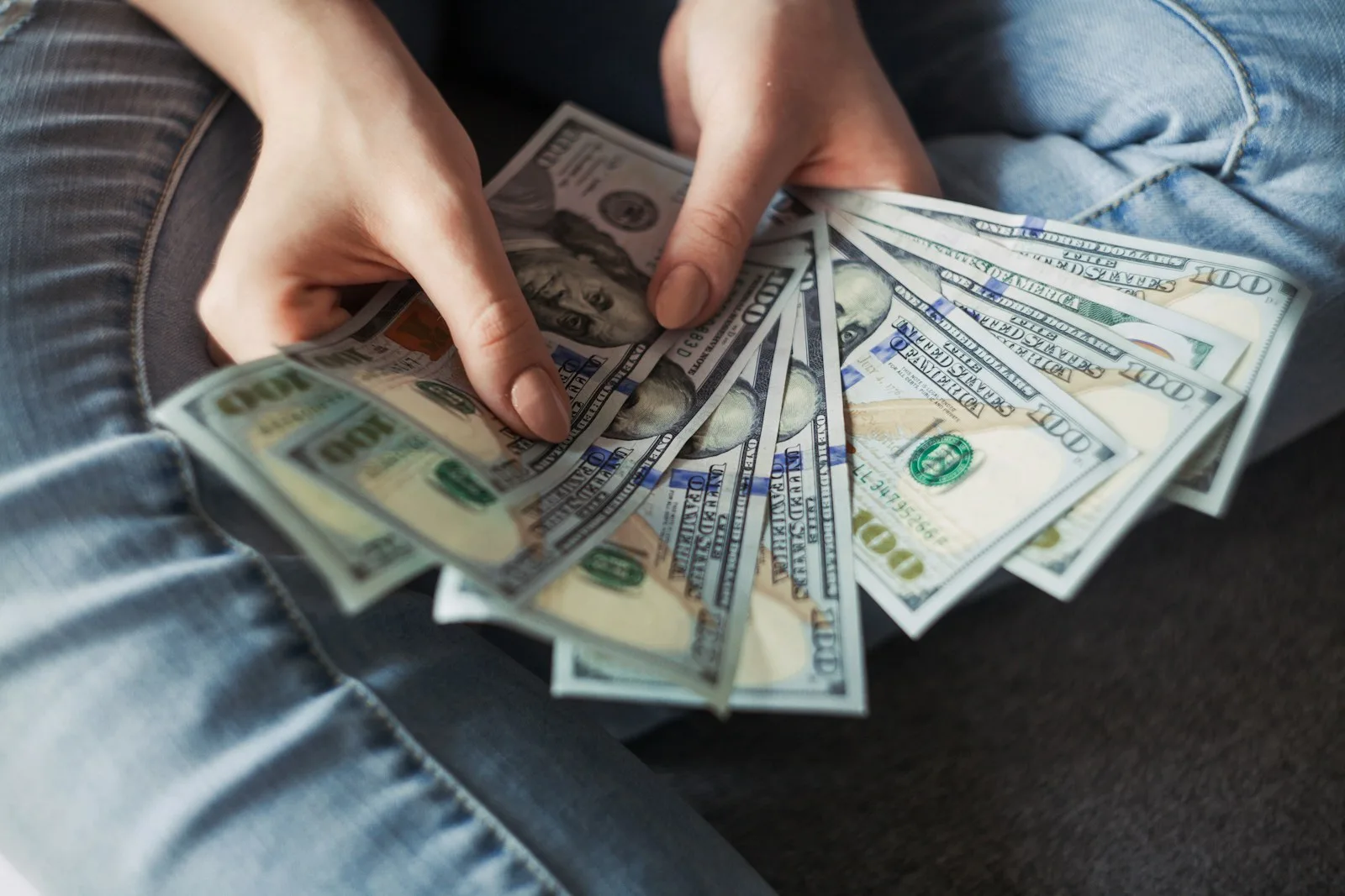 A lady counting dollar bills after receiving payments from her side hustle.