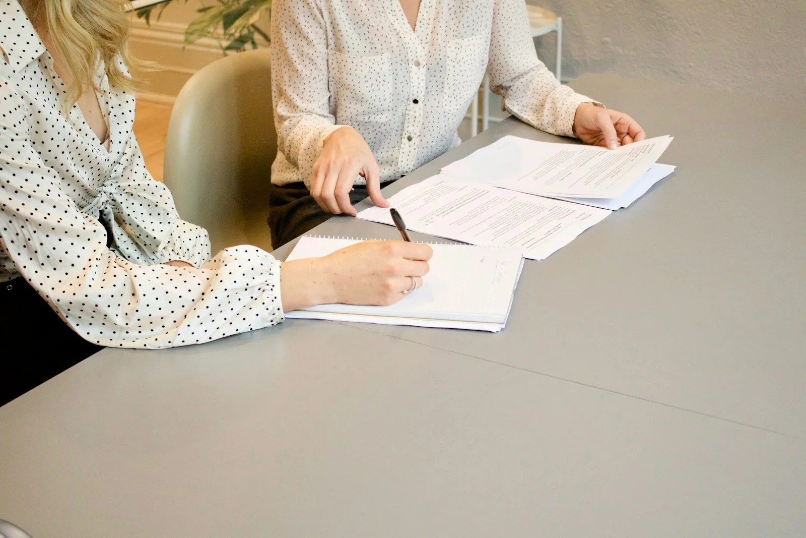 Two person negotiating over a deal and signing paperworks